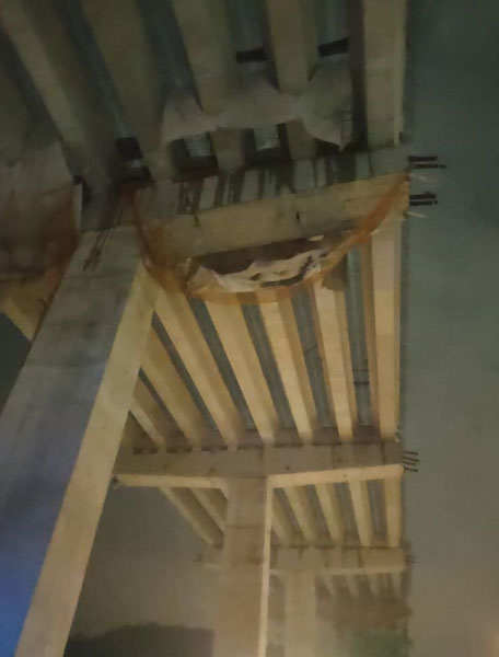 一个施工中的高架天桥，部分水泥混凝土和铁枝突然塌下，坠落在行驶中的一辆马赛地轿车。