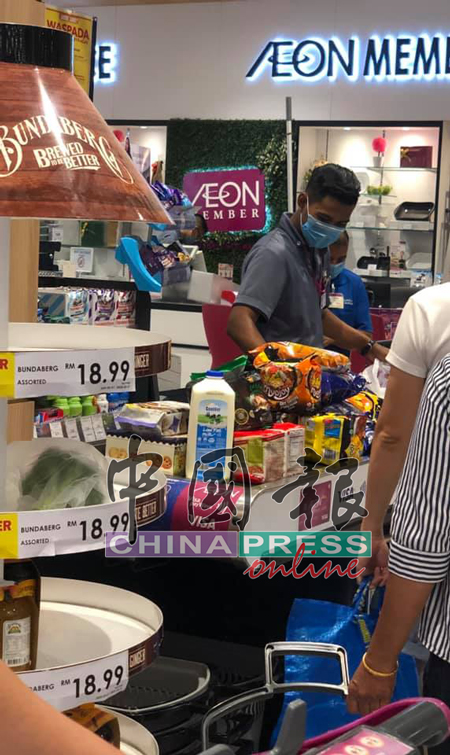 商场职员忙着为公众结账,柜台上堆满商品。