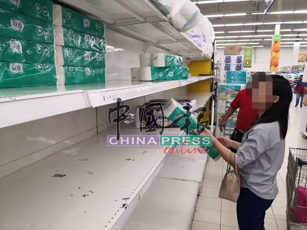 一名公众在商场内选购厕纸。