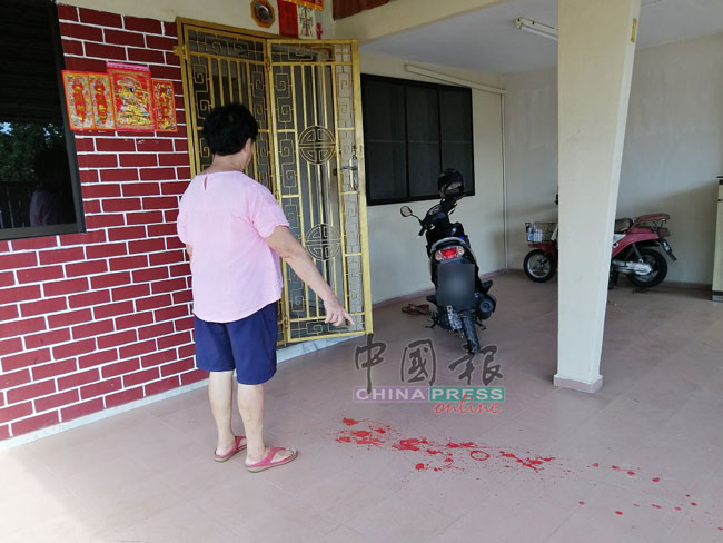 陈太太指着地板上的红漆，希望大耳窿搞清楚住址，不要再来骚扰。