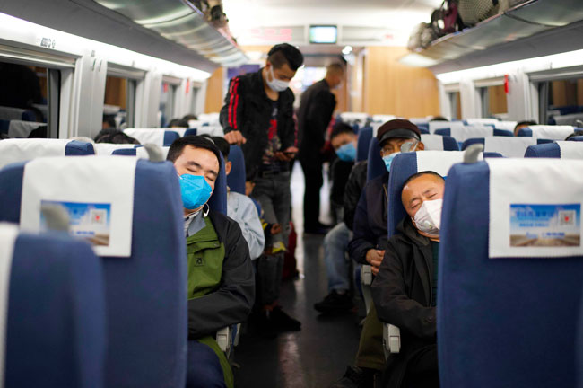一列列车周三停在湖北省麻城地铁，可见多名乘客戴着口罩睡觉。（法新社）