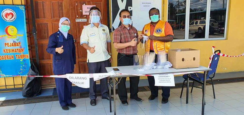 丘梦兴（左2）连同杰苏达斯（右），移交自制3D打印防护面罩予淡边政府诊疗所医务人员。