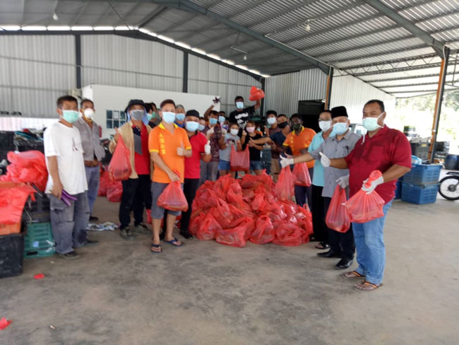 慕哈兰（右起）、峇哈鲁丁、陈春秀、陈清鸿（左）与义工，合力为蔬菜包装成一袋袋。