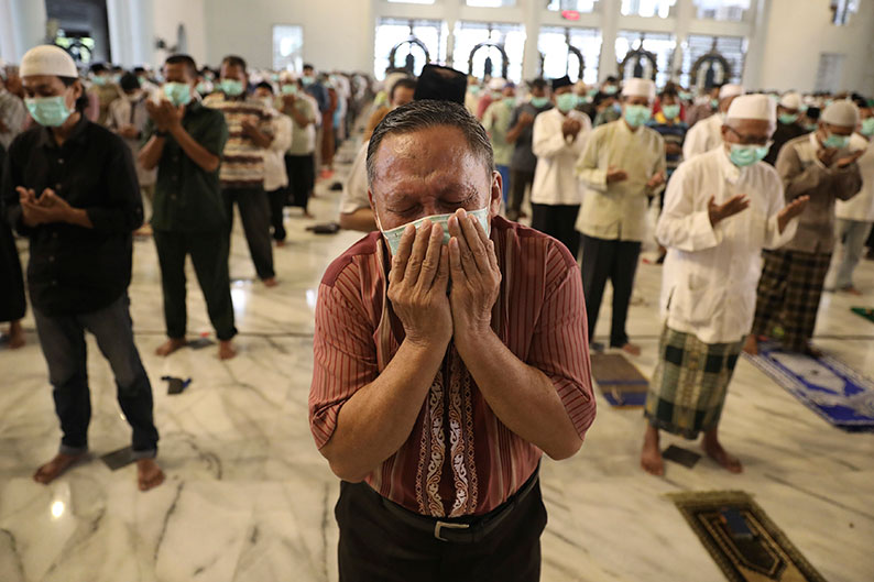 泗水一名男子周五在清真寺祈祷，一边掉眼泪。（美联社）