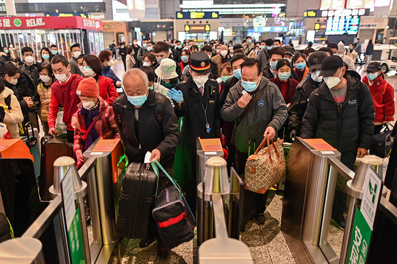 武汉火车站周六解封重开，大批戴着口罩的乘客涌进入站。