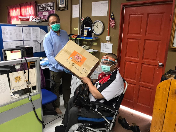 徐港智（左）移交防护面罩给法德里医生。