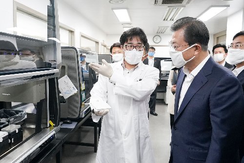 韩国总统文在寅（右）周三视察位于首尔的生物技术公司Seegene，该公司全力投入防疫相关研究，并在2月初推出第一版新冠病毒检验试剂组。（法新社）