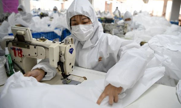 在浙江温州一家工厂，工人们在制作防护服。