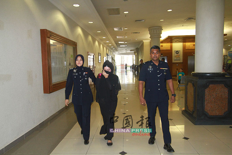 艾妮（左2）被警员带到推事庭接受审讯。