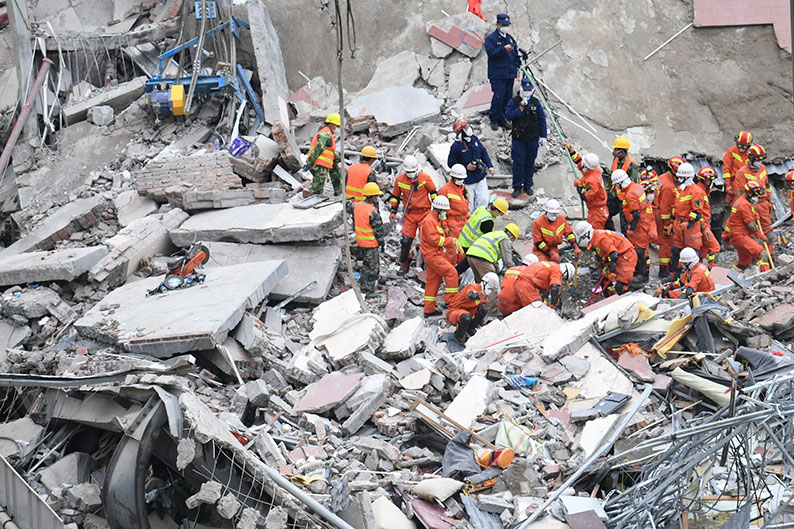 搜救人员周日在欣佳酒店的废墟展开搜救工作。（美联社）