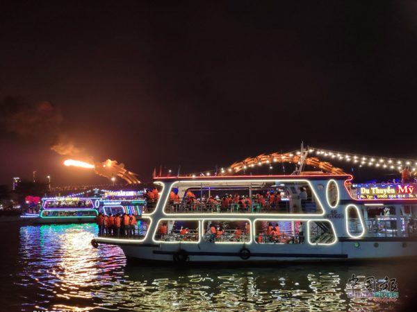 夜晚，岘港龙桥，灯光灿烂，观光船都围笼过来看热闹。龙喷火，红红火火，旺呀！