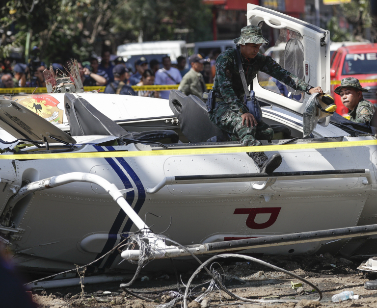 直升机坠毁在拉古纳省圣佩德罗市一处住宅区，警方调查员抵达现场展开调查。（美联社）