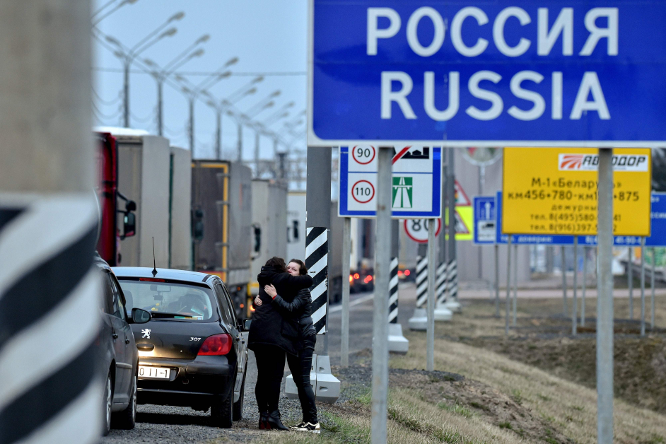 俄罗斯周一正式封锁边境。图为周日在俄罗斯和白罗斯边境，2名即将分离的女子互相拥抱道别。