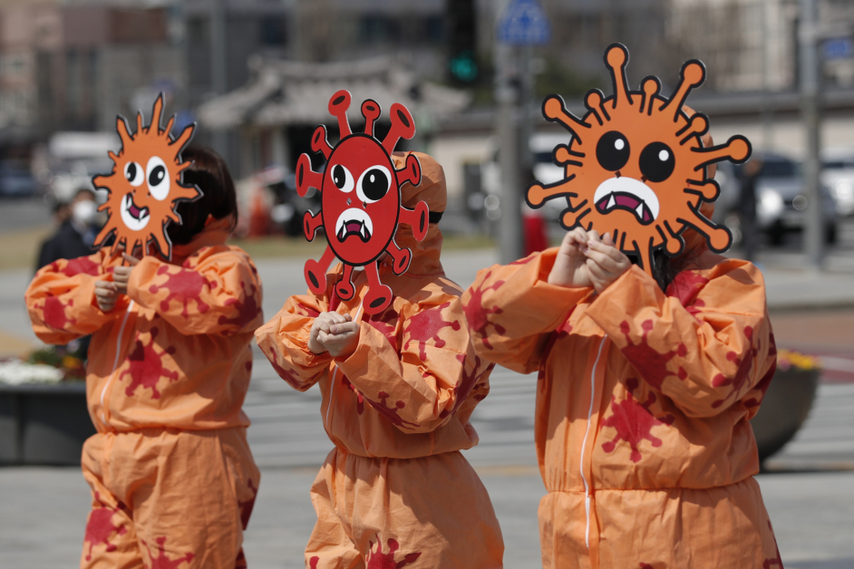 戴“新冠肺炎病毒”面具和服装的爱护环境人士，30日在韩国首尔举行的防疫运动中表演。（美联社）