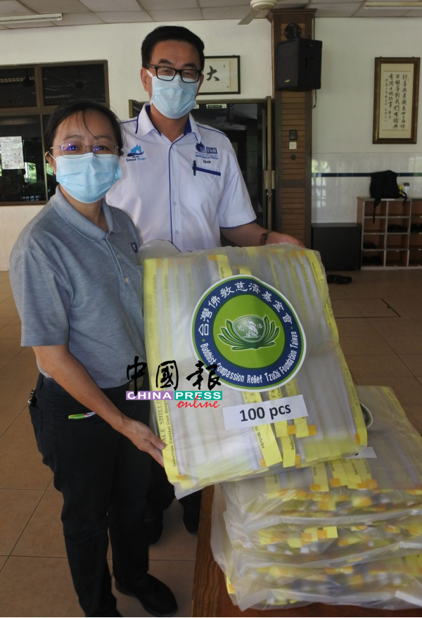 方莉霞（左）展示已完成并准备交给中央医院的防护面罩，右为吴旺新。
