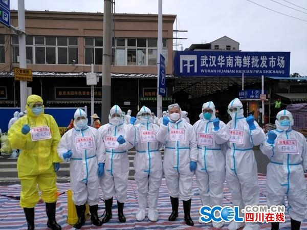 穿着防护服来自四川的9名疾控队员，在华南市场前合照。