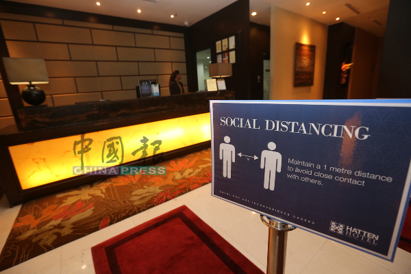 惠胜酒店接待柜台设有告示牌，促请顾客必须保持至少1公尺安全距离。