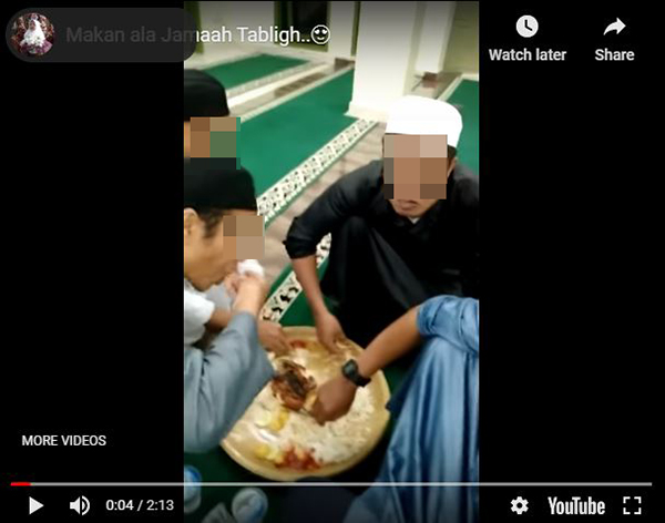 参与伊斯兰传教士集会者共享同一盘饭菜，并用手进食。（截图取自YouTube）