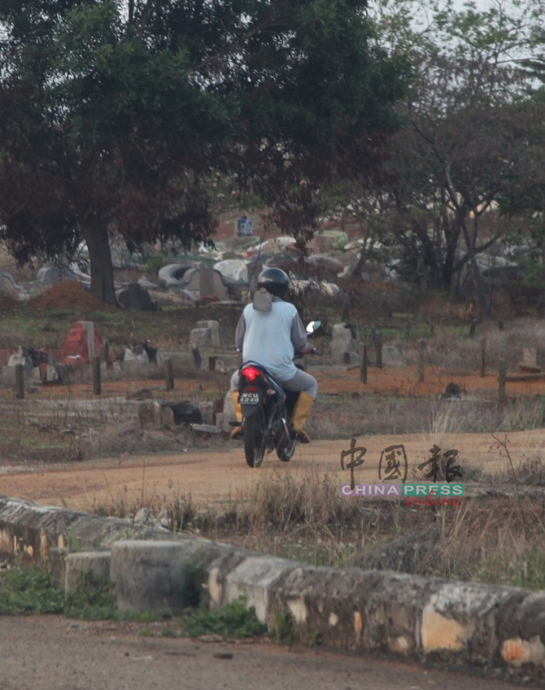 墓园管理员仍携带锄草工具在日落洞华人义山巡视，以防万一有民众扫墓。