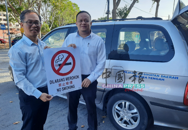 刘志良（左）移交商家报效的禁烟告示牌给甲中央县卫生局官员阿末。