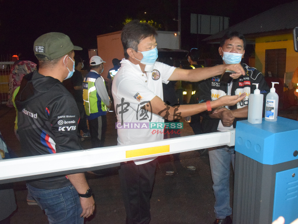 拉末马里曼（右起）、宋曜强、沙丹奥斯曼进入峇株安南批发公市之前，使用搓手液消毒。