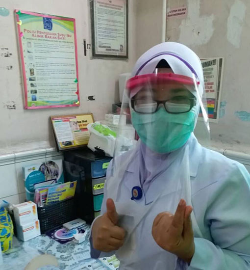 医护人员戴上黄松毅与团队制作的可拆式防护透明面罩，竖起拇指赞好。（受访者提供）