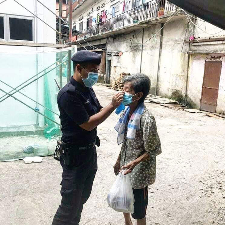 警员替老妇带好口罩。