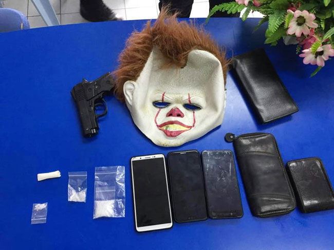 警方在嫌犯轿车起获一个小丑面具、3台手机、皮包、一把短枪和数包毒品。