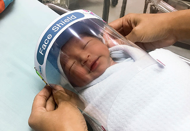 在泰国北榄府的一间医院，护士为新生儿戴上面罩，防止他们被感染新冠病毒。（美联社）
