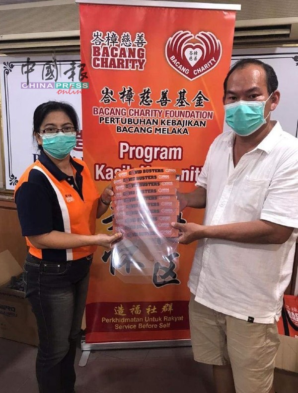 峇章慈善基金关爱队副主任林柳丝（左）移交防护面罩，给武雅拉也商家居民协会主席梁证法。