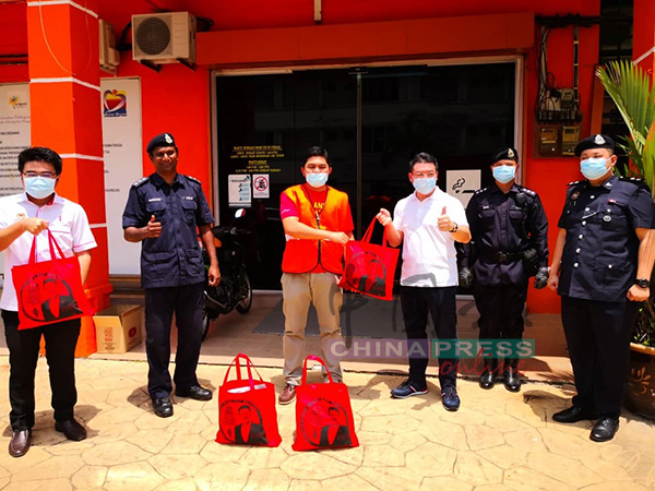 倪可敏（右3）赠送口罩及物资，给福利局及警方代表。