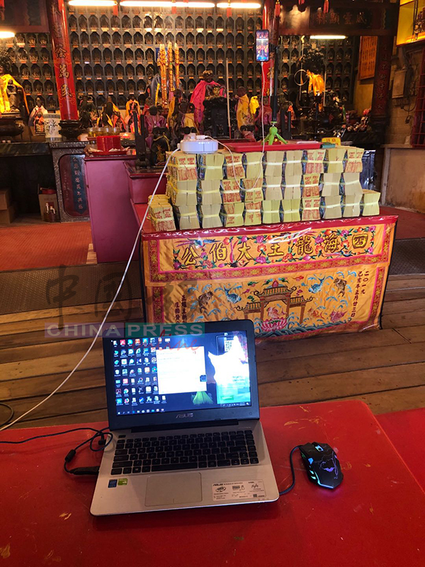四海龙王大伯公庙理事会用手提电脑及手机，在面子书进行直播，让善信在线上膜拜神明。