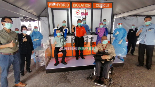 法德利（坐轮椅者）与医务前线人员接领综合隔离柜。