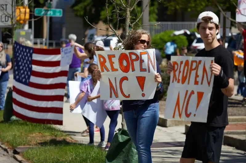 美国北卡州罗里市民众4月14日上街示威，反对政府的居家避疫规定。