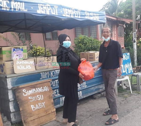 马来妇女向依斯迈索取粮食包。