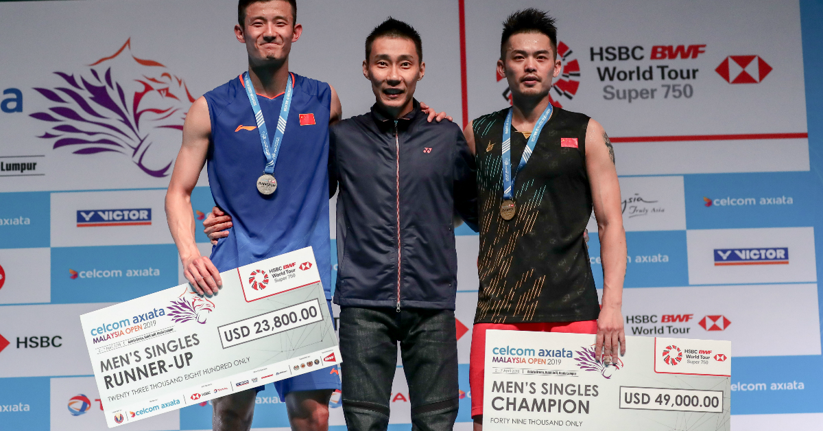 2019年4月7日，林丹（右）、谌龙（左）与颁奖嘉宾李宗伟在领奖台上合影。 当日，在吉隆坡举行的2019年马来西亚羽球公开赛男单决赛中，林丹以2比1战胜队友谌龙，夺得冠军。 （ 新华社档案照）