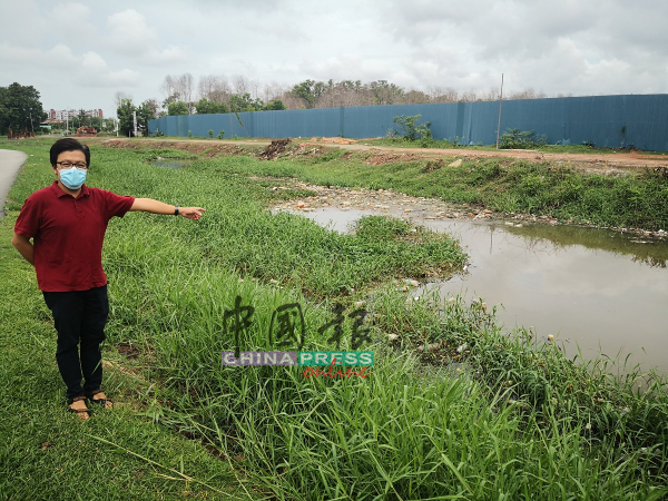 李春源展示堆满杂草及垃圾的河流。