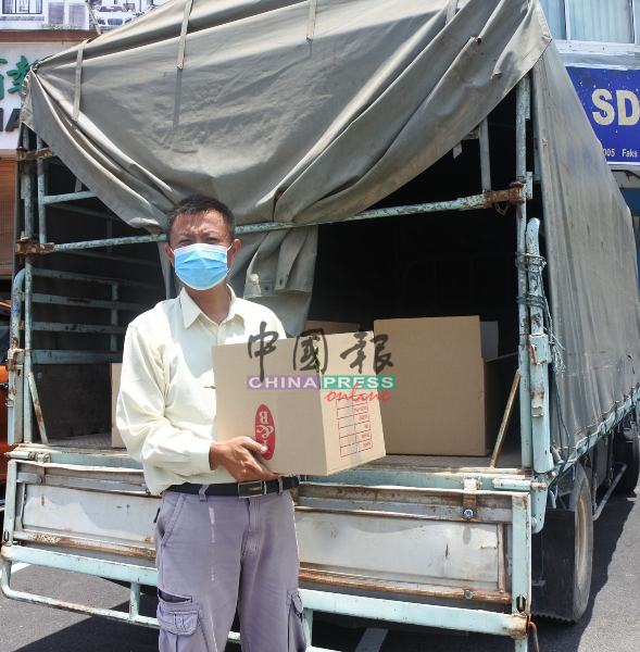 吴锦雄在管制令期间，载着蔬菜到特定地点供订菜的民众领取。
