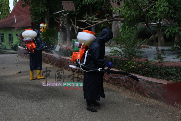 动物管理员全副武装，在马六甲动物园范围内展开消毒工作。