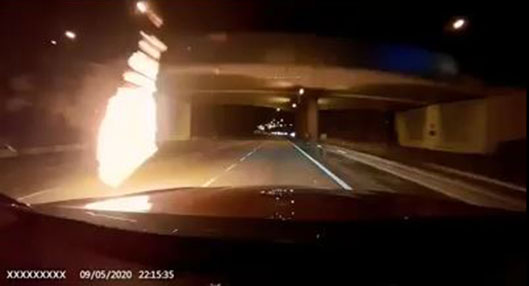 相信是汽油弹的“火球”从天桥落下，和轿车擦身而过。