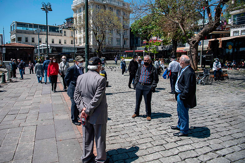 多名长者周日在伊斯坦布尔的奥尔塔柯伊海边闲聊，彼此间不忘保持社交距离。（法新社）