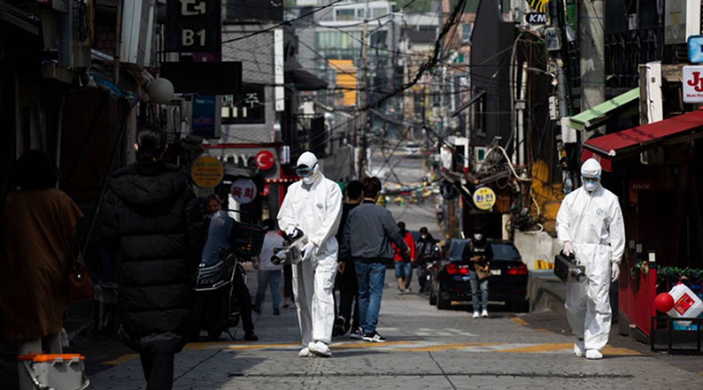 工作人员身穿防护服，在首尔梨泰院的街道进行消毒工作。 （互联网）
