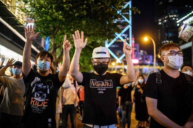 香港金钟区太古广场购物中心外，游行示威者15日举行守夜活动，示威者比出了“五大诉求，缺一不可”的手势。（法新社）