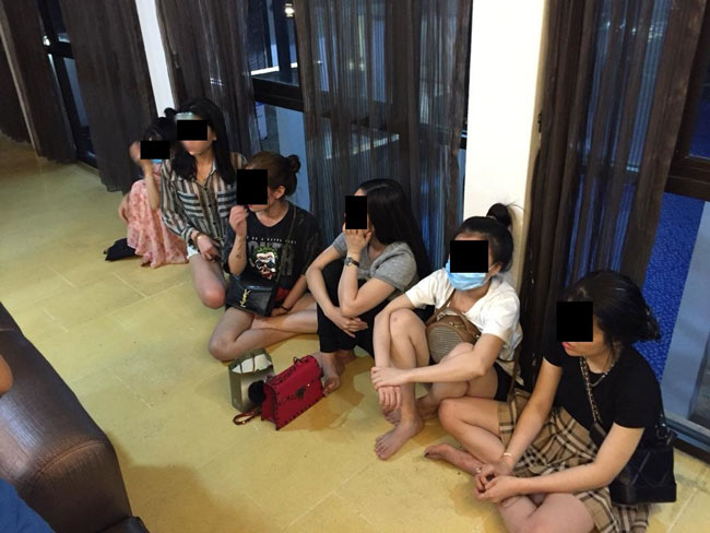 落网年轻女子坐在一旁，等待警方调查。