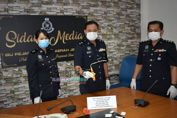 莫哈末凯里（中）向媒体展示吸毒者所使用的自制吸毒器。