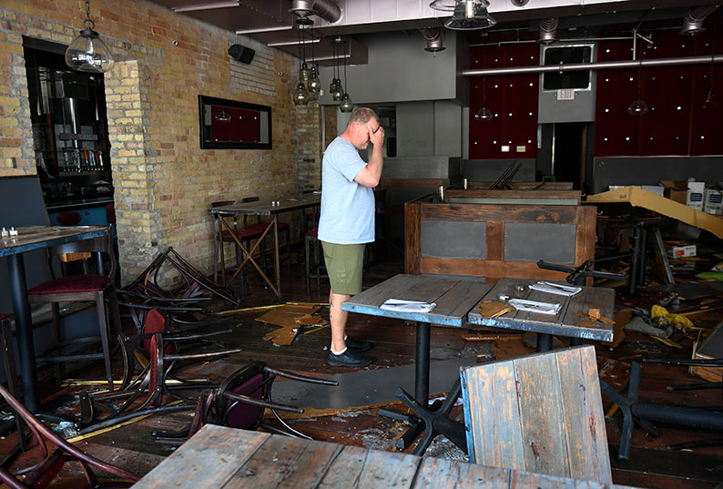 明尼阿波利斯市一家餐厅老板，周四眼看自己的餐厅被人破坏成这样，掩面痛哭。（欧新社）