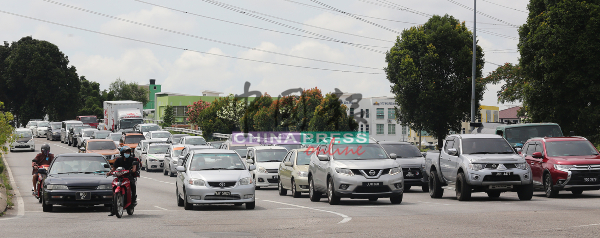 靠近峇章北添宫的AMJ大道红绿灯前，集聚不少车辆，等待前往上班或办事。