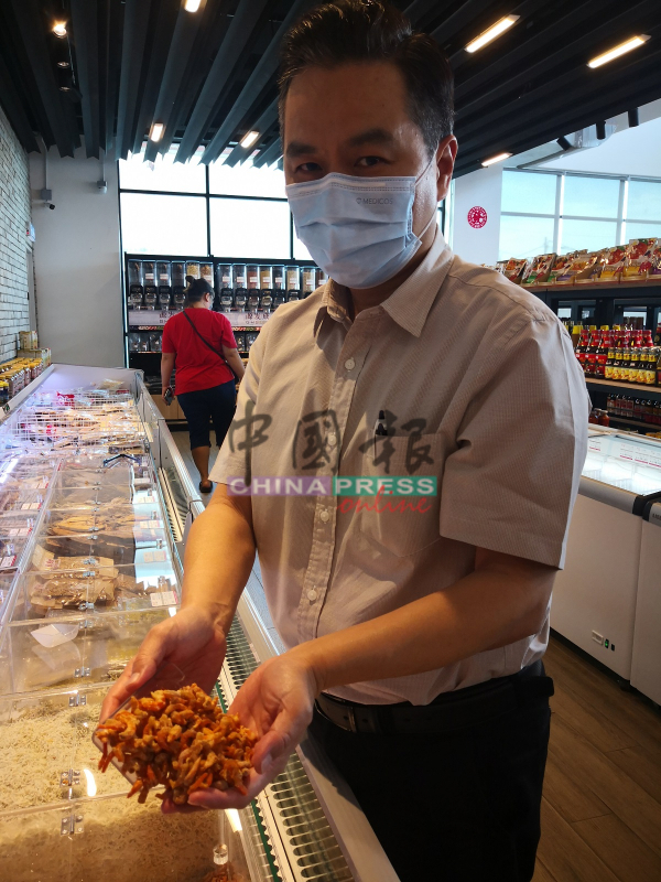 杨添毅展示店内所售卖的虾米。
