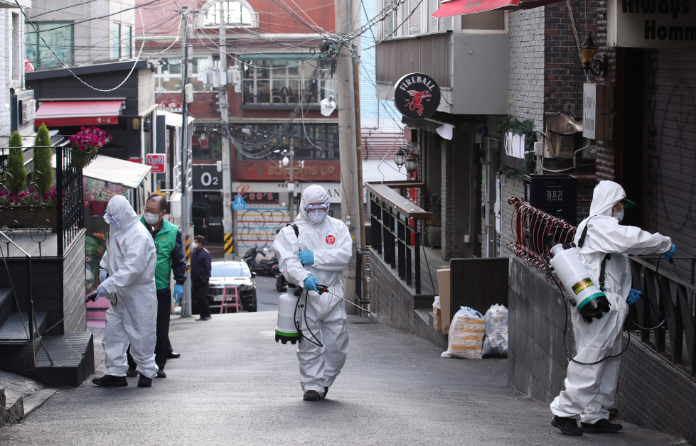 卫生人员在首尔梨泰院区的一条街道上喷洒消毒剂。（法新社）