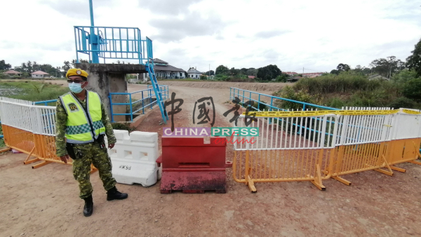 志愿警卫团员把围绕着花海聚水池的出入口围上护栏，以免民众蜂拥赏花。